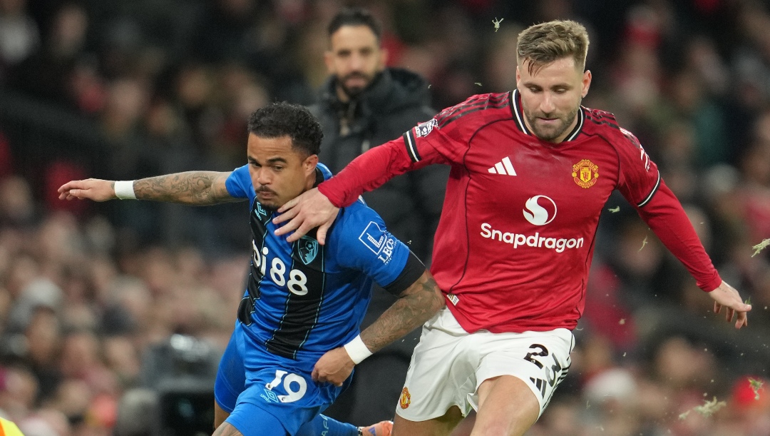 Bournemouth's Justin Kluivert, left, and Manchester United's Luke Shaw fight for the ball during a Premier League soccer match between Manchester United and Bournemouth in Manchester, England, Monday, Dec. 15, 2025.