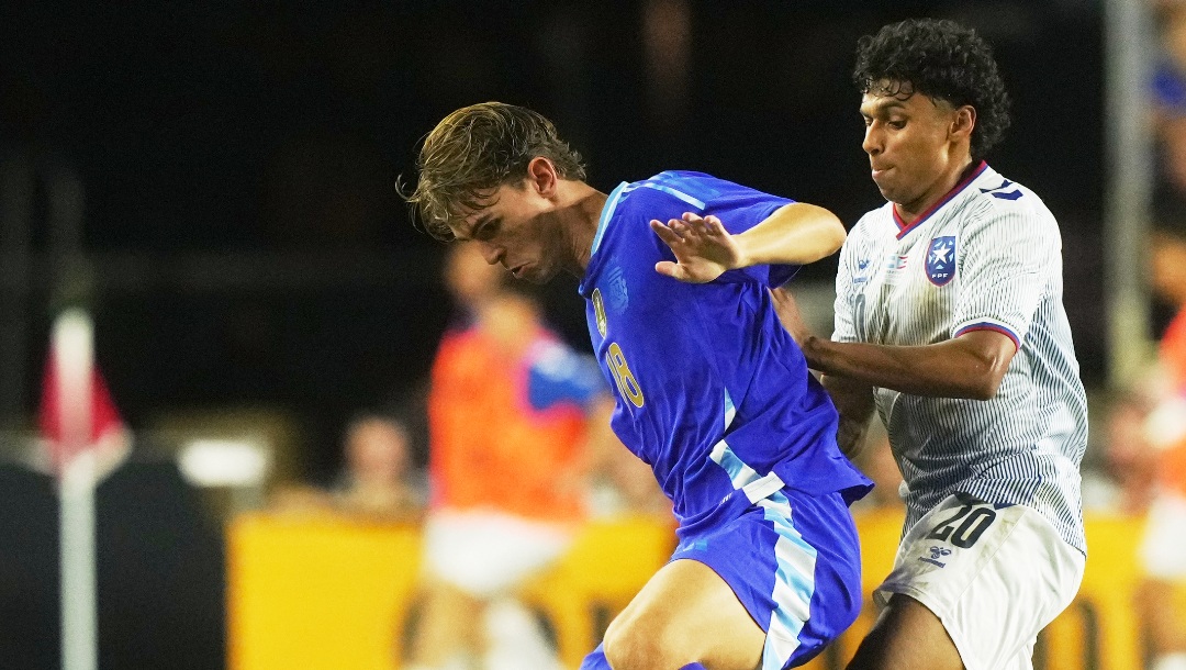 Puerto Rico's Sidney Paris (20) defends Argentina's Nico Paz (18) during the second half of a friendly soccer match, Tuesday, Oct. 14, 2025, in Fort Lauderdale, Fla. (AP Photo/Marta Lavandier)