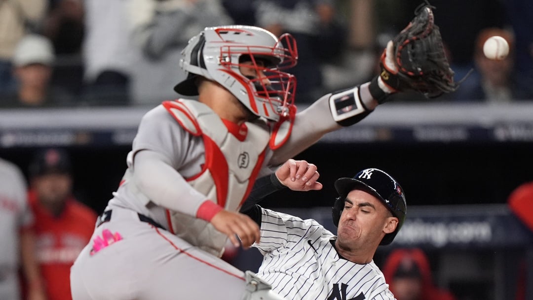 New York Yankees' Cody Bellinger slides safely into home plate to score ahead of the tag from Boston Red Sox catcher Carlos Narváez (75) during the fourth inning of Game 3 of an American League wild-card baseball playoff series, Thursday, Oct. 2, 2025, in New York. (AP Photo/Frank Franklin II)