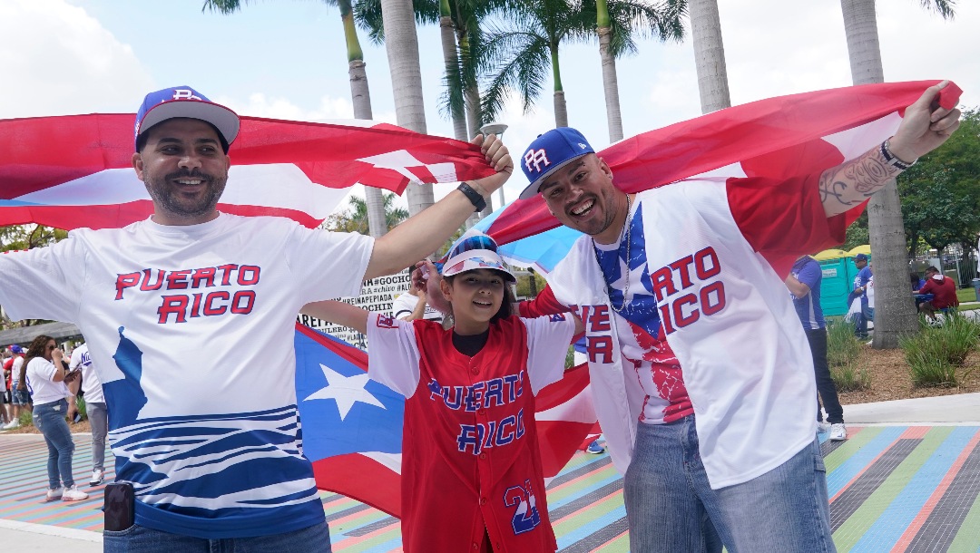 Puerto Rico fans David Torres, left, Nyssa Santiago and Javier Andino enter the stadium for a World Baseball Classic game between Puerto Rico and Nicaragua, Saturday, March 11, 2023, in Miami. (AP Photo/Marta Lavandier)