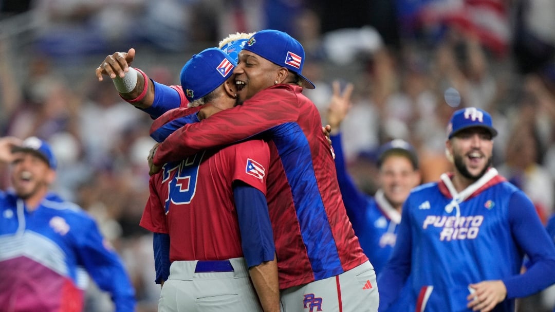 Puerto Rico pitcher Edwin Diaz, foreground is mobbed by teammates after Puerto Rico beat the Dominican Republic 5-2 during a World Baseball Classic game, Wednesday, March 15, 2023, in Miami. Diaz appeared to injure himself during the postgame celebration. (AP Photo/Wilfredo Lee)